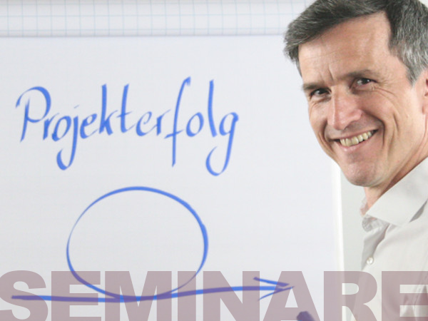 Mann leitet passgenaues Seminar und Training zur Führungskräfteentwicklung vor Flipchart mit der Beschriftung Projekterfolg