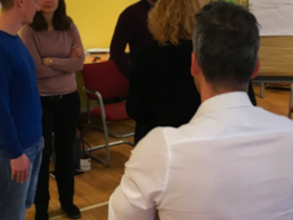 Eine Gruppe in einem Workshop zur Teamentwicklung in Zyklen zur Verbesserung ihrer Zusammenarbeit.
